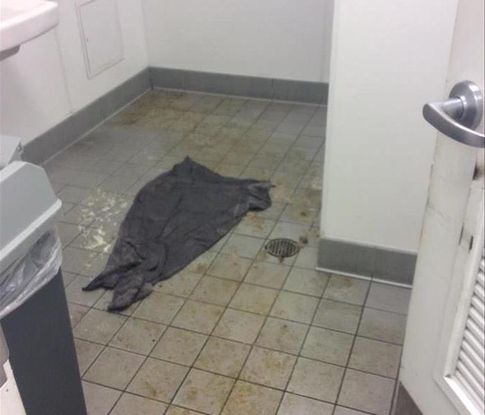 contaminated material in water on tile floor in ross bathroom