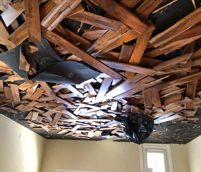 damaged wooden flooring piled in middle of room
