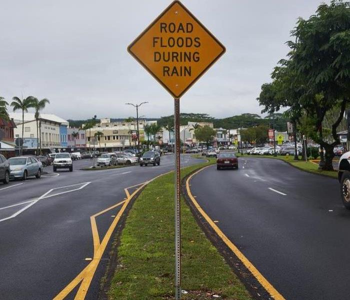 A sign on the road that cautions drivers "Road Floods During Rain" 